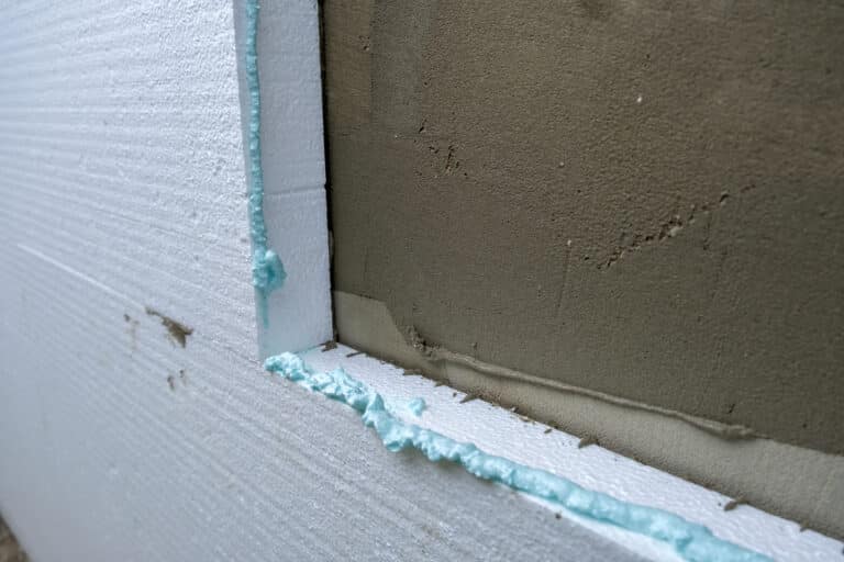 installation of styrofoam insulation sheets on house facade wall for thermal protection.