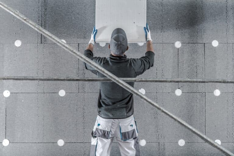molded graphite polystyrene house insulation by caucasian contractor worker.
