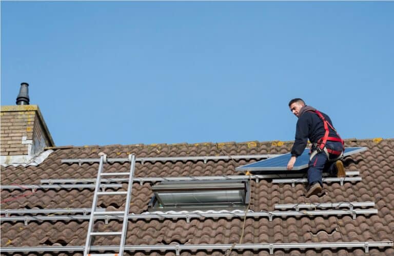 man putting the solar panel to the metal construction on the roof
